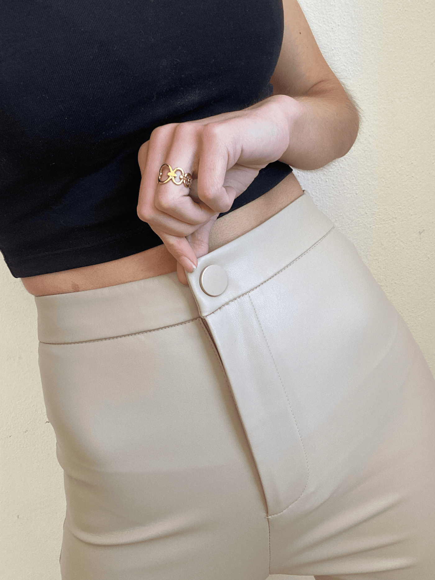 pantalón de cuero claro con botón plateado